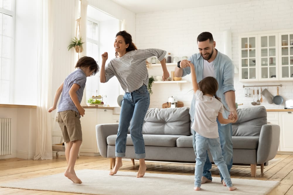 full,length,overjoyed,family,of,four,jumping,to,music,in