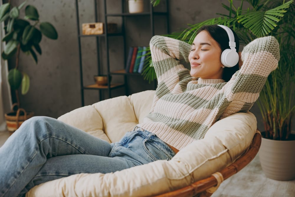 Jeune femme calme, vue de côté, portant des vêtements décontractés et écoutant de la musique