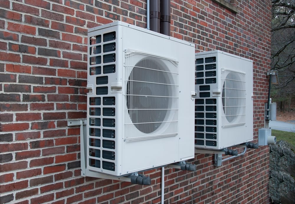 pompes à chaleur modernes installées sur un mur de briques